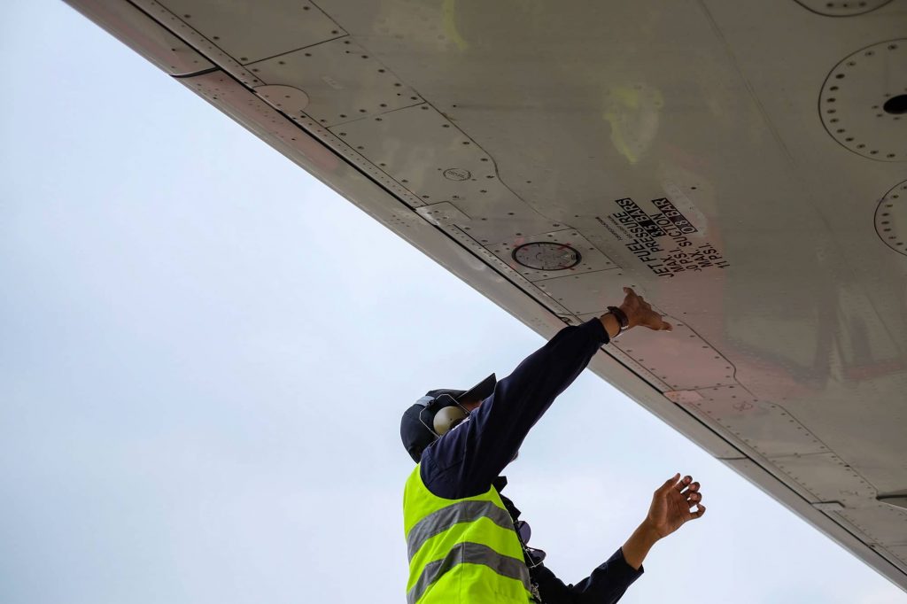 Airplane technician working a plane wing