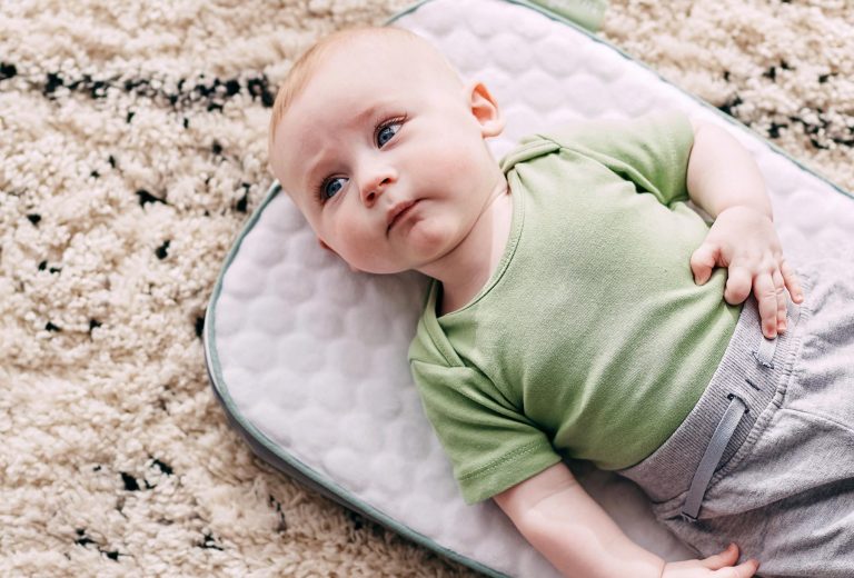 Baby lying on a wool mat